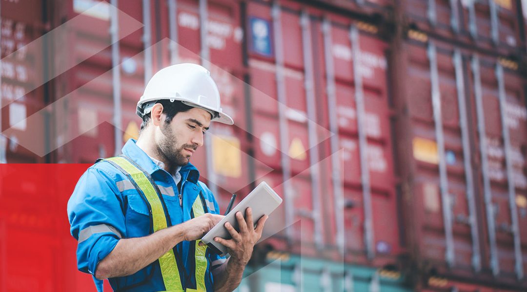 worker looking at his ipad in front of cargo